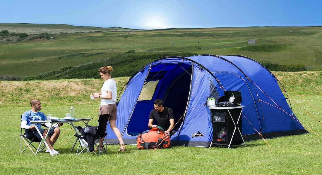 Familie ist vorm Zelt auf dem Campingplatz