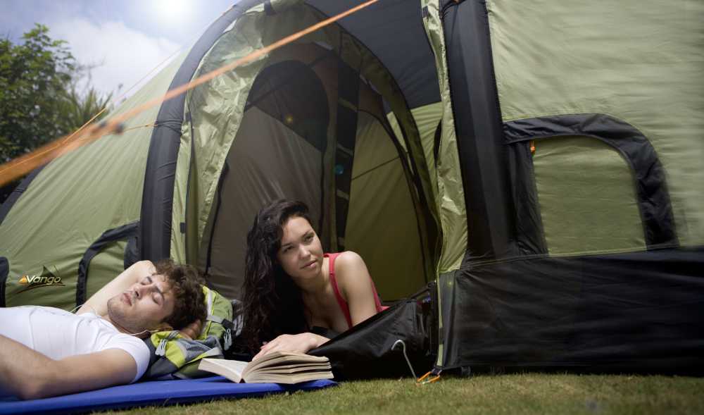 Pärchen liegt auf Isomatten vor einen Zelt