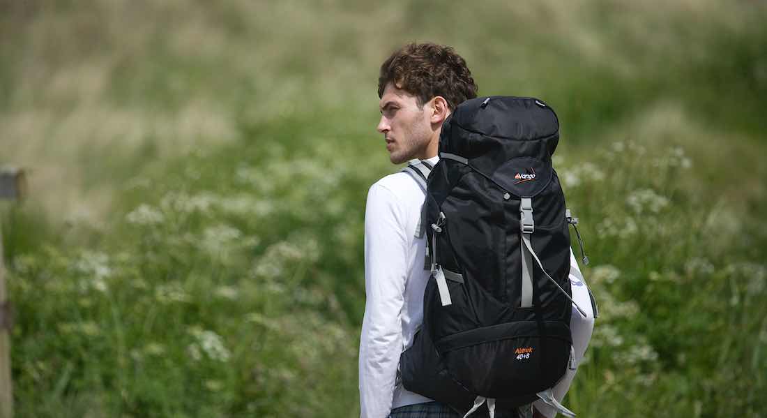 Junger Mann auf der Trekking-Tour mit Rucksack